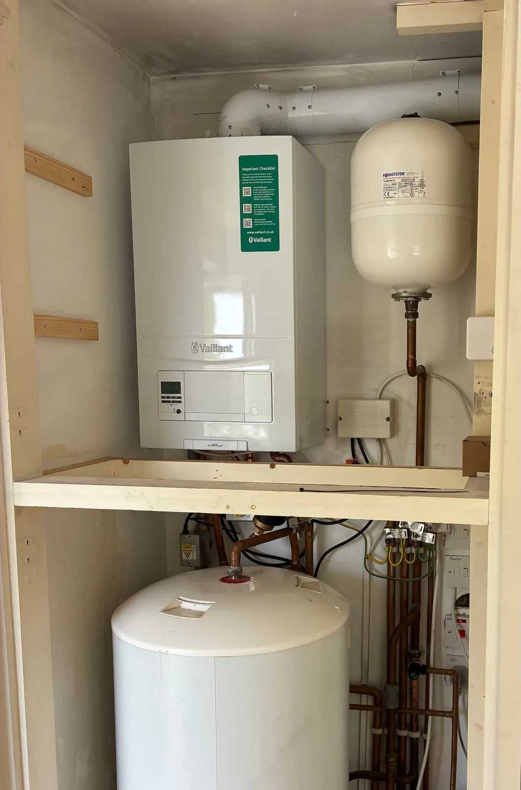 Vaillant combi boiler installed above a hot water cylinder and expansion vessel